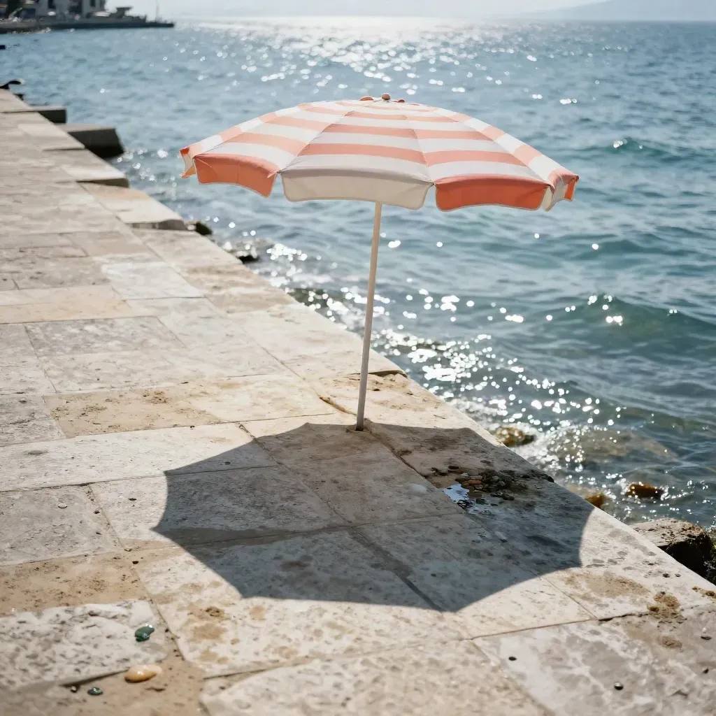 İzmir sahilinde taş promenad, tek şemsiye ve parlayan su yüzeyi.